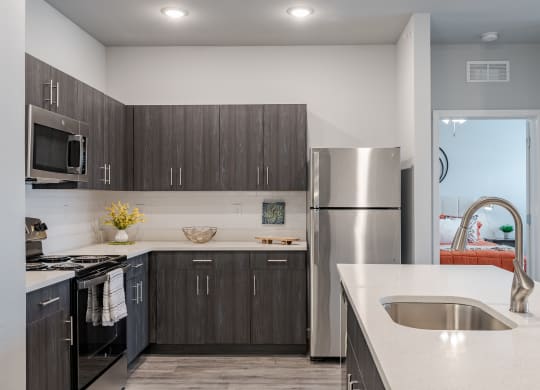 an updated kitchen with stainless steel appliances and white countertops
