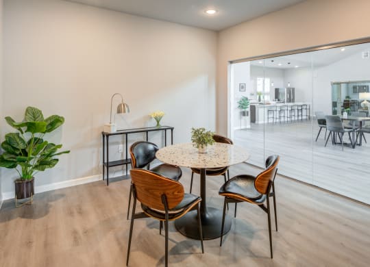 a dining area with a round table and chairs in front of a sliding glass door