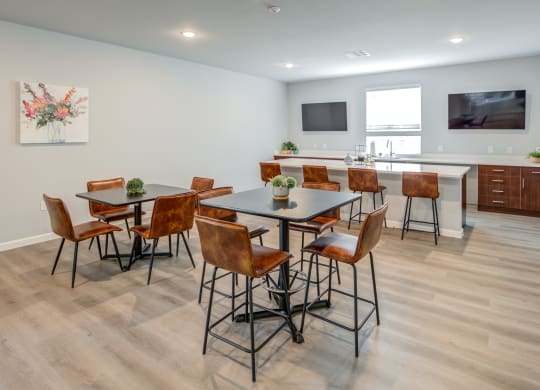a dining area with a table and chairs and a kitchen with a television