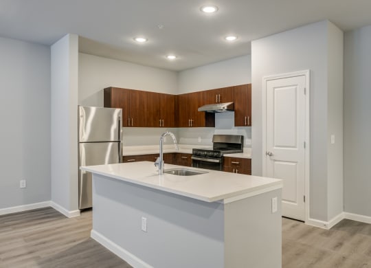 a kitchen with an island and a stainless steel refrigerator