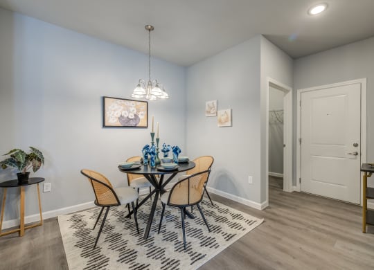a dining room with a table and chairs and a door to a bathroom