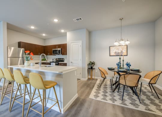 an open kitchen and dining area with a dining table and chairs