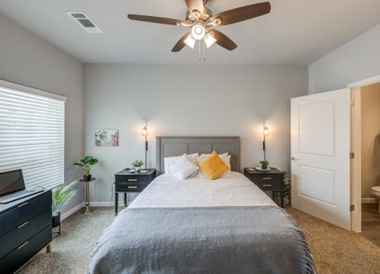 a bedroom with a large bed and a ceiling fan