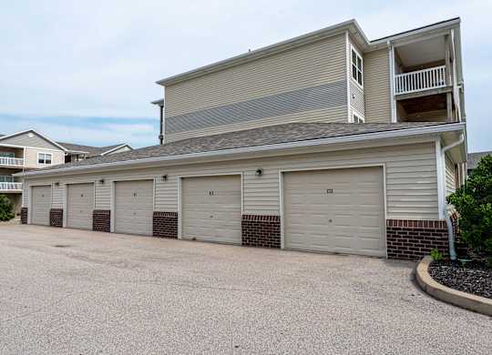 a garage with a row of white doors on the side of a house