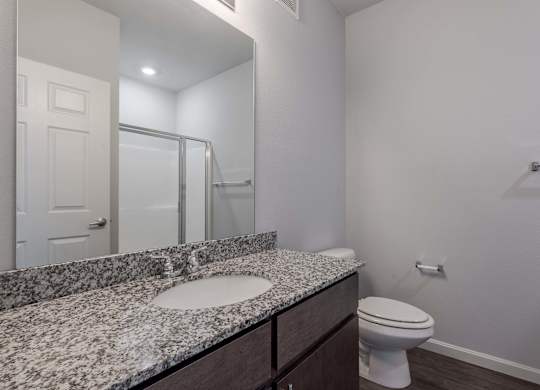 the ensuite bathroom of our studio apartment atrium with shower and sink and toilet