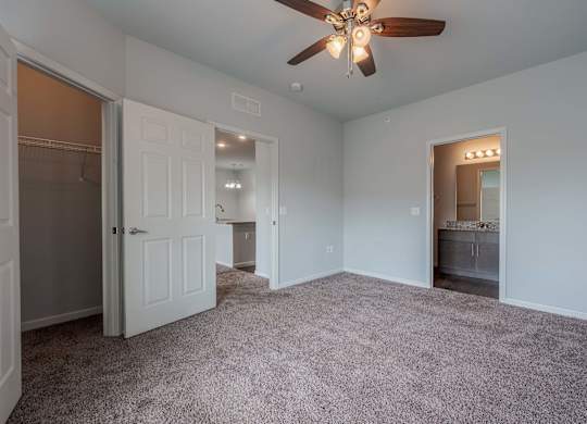 a bedroom with a ceiling fan and a closet