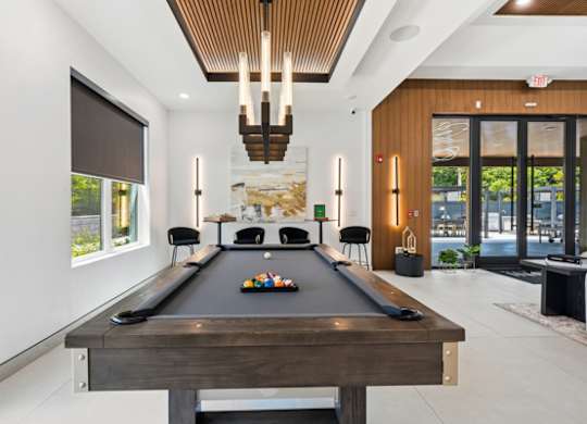 Billiards room with pool table and modern lighting at The Franklin at Marlboro Apartments, Marlboro, NJ