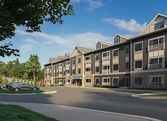 A modern apartment complex with a car parked in front.