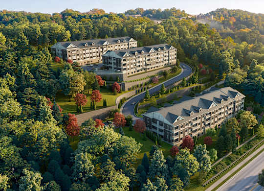 A large building complex is surrounded by trees in the image.