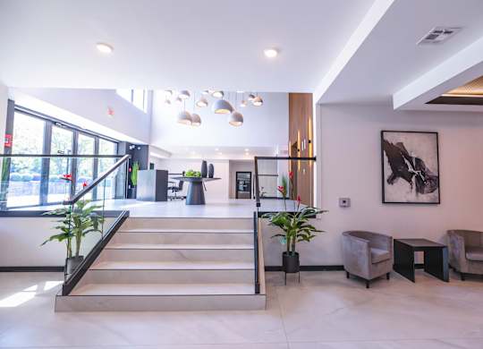 A spacious lobby with a staircase, chairs, and a large painting on the wall.at The Franklin at Westfield, New Jersey, 07090