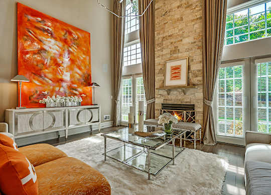 A living room with a fireplace and a large painting on the wall.