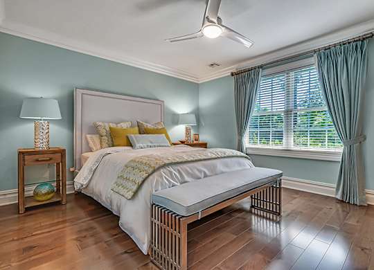 A bedroom with a bed, nightstand, and window.