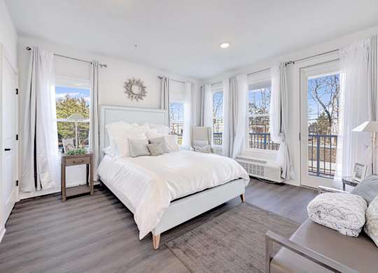a white bedroom with a large bed and windows at The Franklin at Hillsborough Apartments, Hillsborough, New Jersey