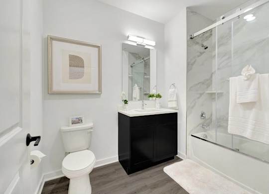 a bathroom with a shower toilet and a sink at The Franklin at Hillsborough Apartments, Hillsborough, NJ