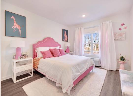 a pink and white bedroom with a bed and a window at The Franklin at Hillsborough Apartments, Hillsborough, NJ 08844