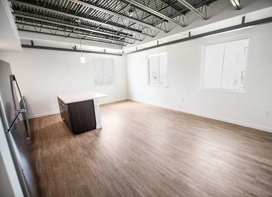 A room with wooden flooring and a black box on the floor at Elements on Third Apartments, St. Petersburg, FL
