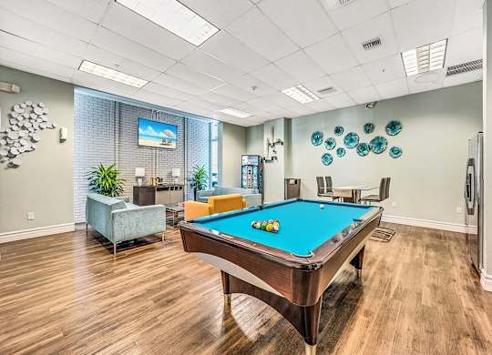 a game room with a pool table and a tv at Elements on Third Apartments, St. Petersburg, FL