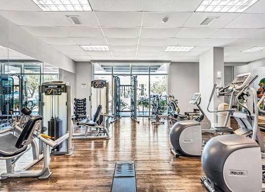 a gym with cardio machines and a wood floor at Elements on Third Apartments, St. Petersburg, Florida