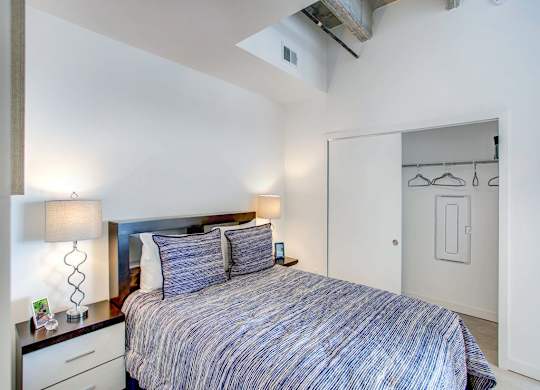 a bedroom with a bed and a closet at Elements on Third Apartments, St. Petersburg