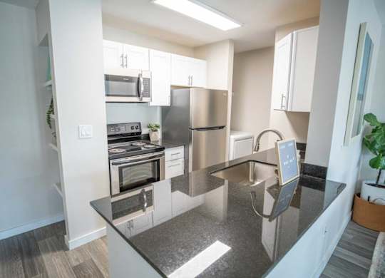 A modern kitchen with a stainless steel refrigerator and microwave.