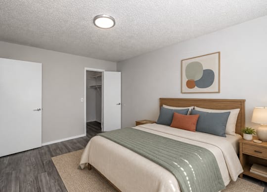 A bedroom with a bed, nightstand, and two doors.