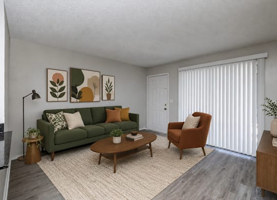 A living room with a green couch, a brown armchair, and a wooden coffee table.