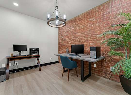 A room with a desk, chair, and computer setup.