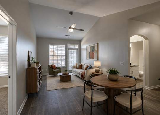 A living room with a couch, a coffee table, and a ceiling fan.