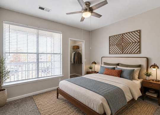 A bedroom with a bed, a ceiling fan, and a window with blinds.