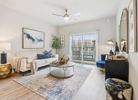 A living room with a white couch, a coffee table, and a painting on the wall.