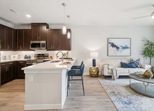 A modern kitchen with a white island and dark brown cabinets.