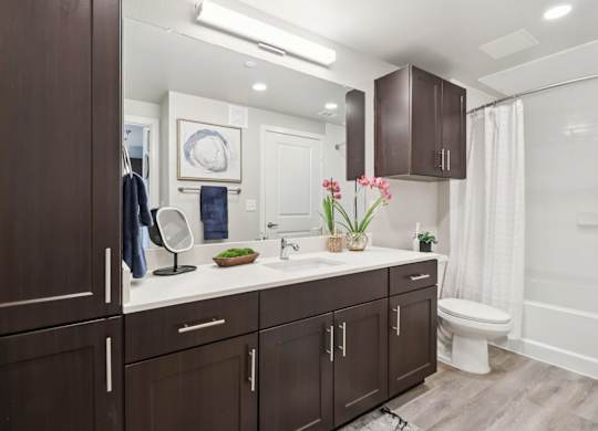 A bathroom with brown cabinets and a white countertop.