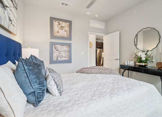 A bedroom with a large bed and a mirror on the wall.