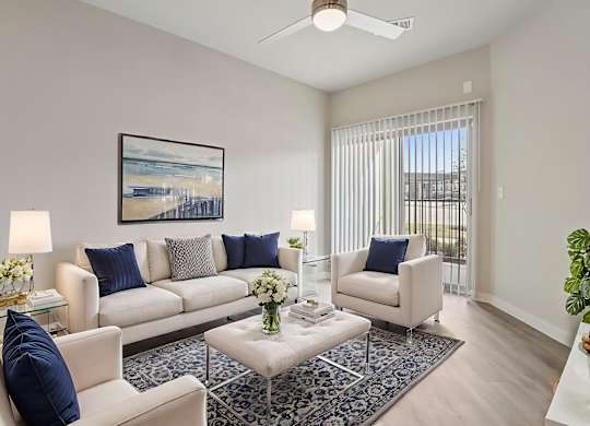 A living room with a white couch, a coffee table, and a painting on the wall.
