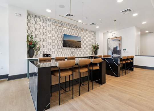 A long black and tan bar with a patterned wall behind it.