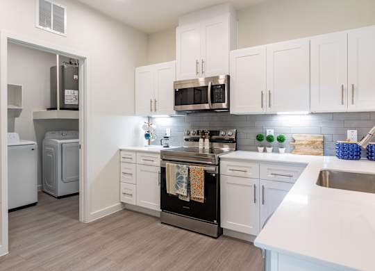 A kitchen with white cabinets and a black oven.