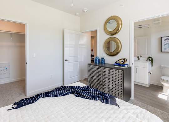 A bedroom with a bed, dresser, and mirror.