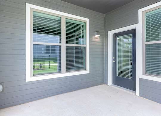 A grey house with a black door and window.