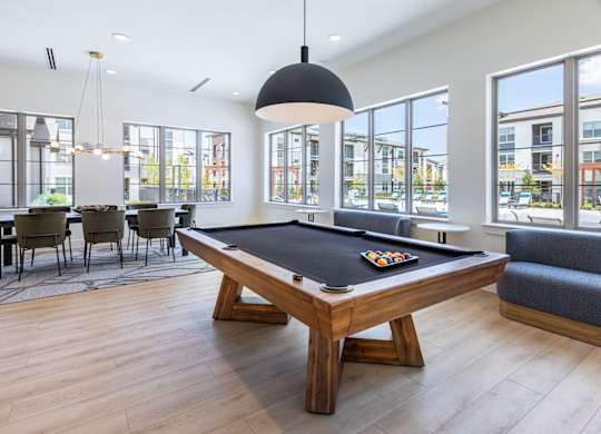 A pool table in a room with a view of the city.