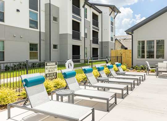 A row of sun loungers are set up outside a building.