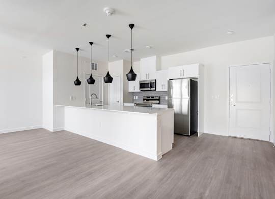 A kitchen with a white counter and a refrigerator.