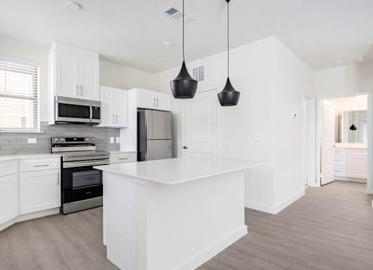 A modern kitchen with white cabinets and a central island.