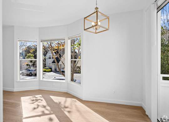 A room with a white wall and a rug on the floor at Westmont Place Townhomes Apartments, Santa Cruz, CA