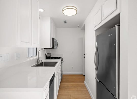 A kitchen with white cabinets and a black fridge at Westmont Place Townhomes Apartments, Santa Cruz, 95060