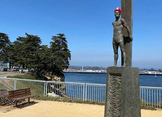 A statue of a man stands on a pedestal by the water at Westmont Place Townhomes Apartments, California