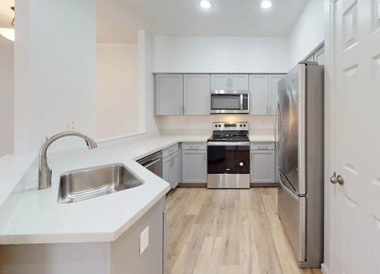 A modern kitchen with stainless steel appliances and white cabinetry.