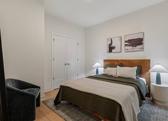 A bedroom with a large bed and two lamps at 7 West 7th Apartments, Cincinnati Ohio