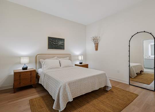 A bedroom with a bed, nightstands, and a mirror at 7 West 7th Apartments, Cincinnati