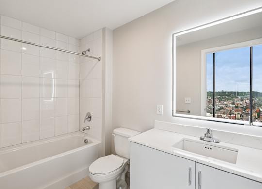 A white bathroom with a toilet, sink, and tub at 7 West 7th Apartments, Ohio, 45202