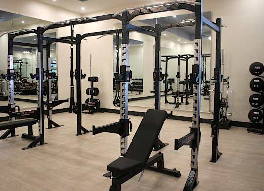 A gym with a variety of equipment including a bench press.